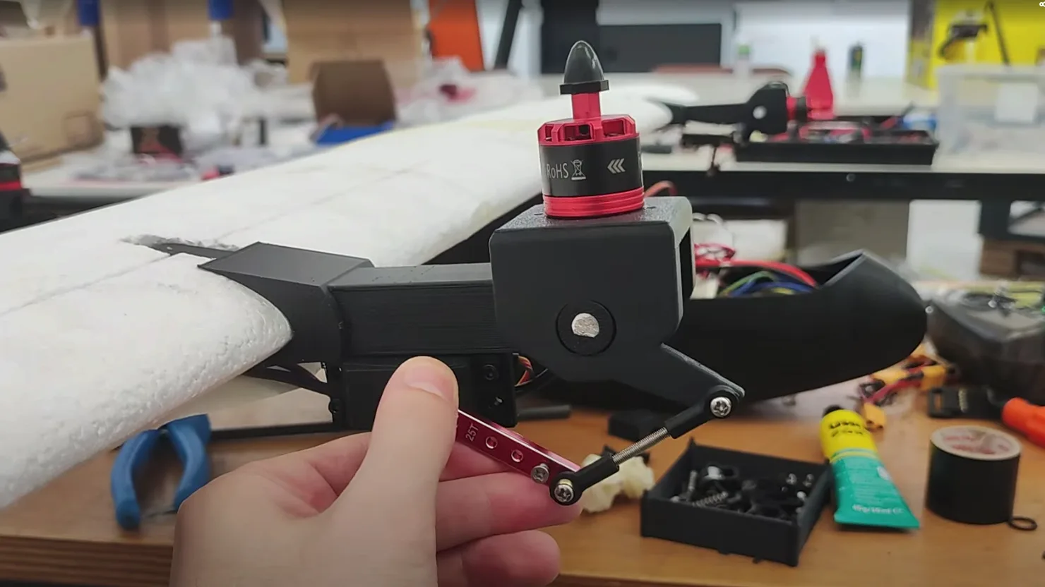 Custom 3D-printed tilt-rotor mechanism mounted to the wing